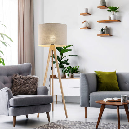 GRAND pine and linen floor lamp shown beside a sofa in a living room