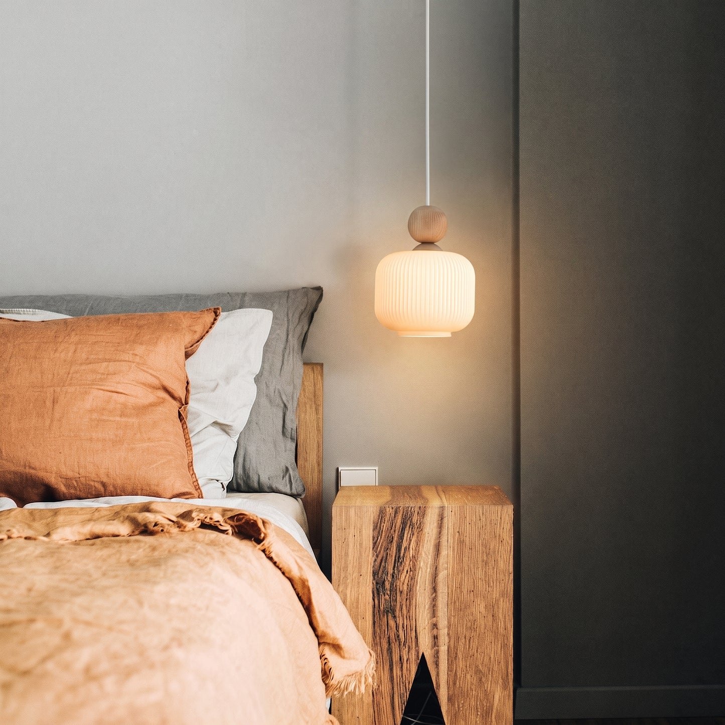 BALLO ribbed glass and wood pendant hanging in a styled space